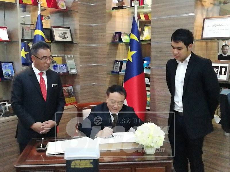 Adly (kanan) memerhatikan Liu Jie menandatangani buku pelawat ketika menerima kunjungan hormat delegasi Wilayah Sichuan di Seri Negeri, semalam.