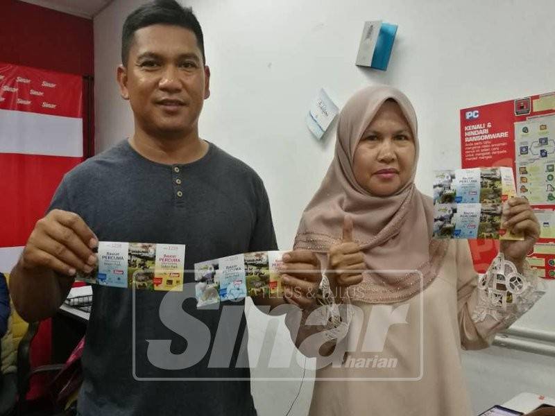 Norhayati bersama suaminya, Mohd Henyzam menebus tiket percuma ke taman tema di Bukit Gambang Resort City di Pejabat Sinar Harian semalam. 