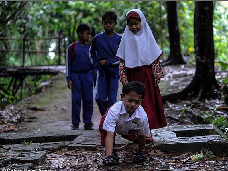 Adul merangkak menggunakan kedua tangan dan kaki ke sekolah sejauh 3 kilometer. - Foto Caters News Agency