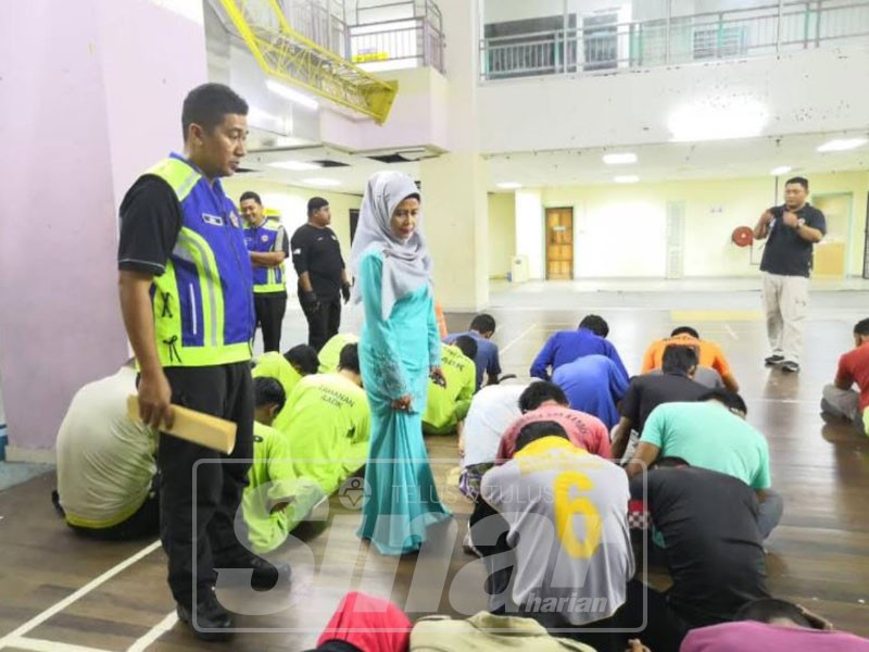 Aman (kiri) mengiringi Rohayu meninjau suspek yang ditahan dalam Operasi Kijang, semalam.