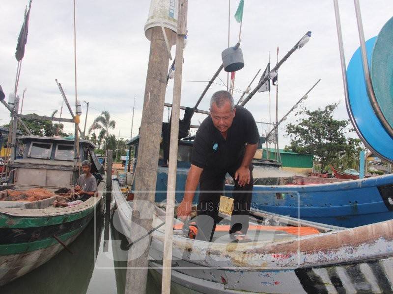 Kamaruddin memeriksa bot bagi membuat persediaan sebelum turun ke laut.