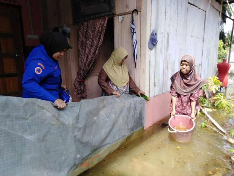 Anggota sukarelawan APM meninjau keadaan banjir di Lorong Pisang, Kampung Asahan yang masih belum surut. - Foto ihsan APM