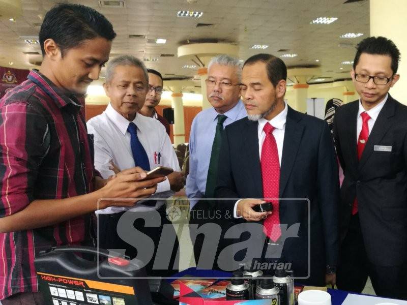 Mohd Nurkhuzaini (dua, kanan) mendengar penjelasan salah seorang usahawan berkenaan produk jualan mereka sempena Sembang Santai Bersama Usahawan Peringkat Kuala Terengganu dan Marang di TTC.