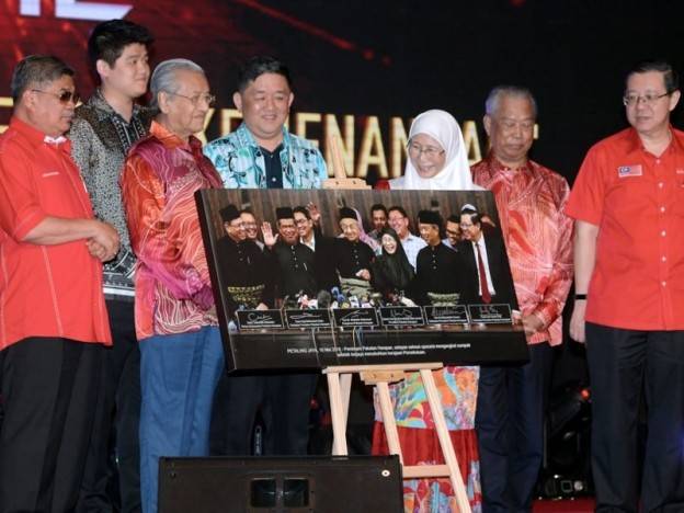 Tun Dr Mahathir Mohamad (tiga, kiri) bergambar bersama pembeli gambar iaitu Pengarah Urusan Platinum Victory Datuk Seri Gan Yu Chai (empat, kiri) dan Pengarah Eksekutif Platinum Victory Gan Yee Hin (dua, kiri) yang telah membida dengan harga RM500,000 pada Majlis Makan Malam Amal Pakatan Harapan 2018 di Pusat Konvensyen Antarabangsa Putrajaya (PICC) malam tadi. - Foto Bernama