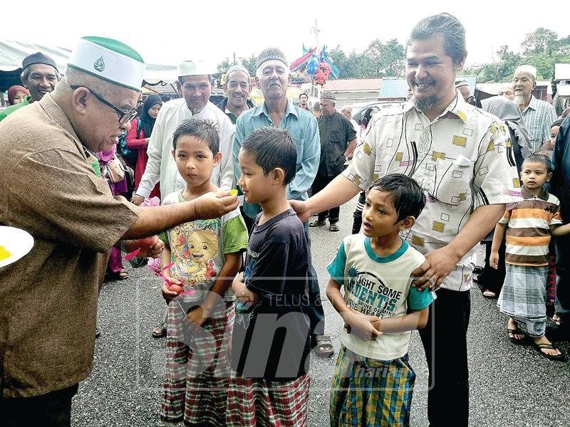 Dua beradik kembar disuapkan pulut semangat oleh Salahhuddin sambil diperhatikan oleh ayah dan adik mereka. 