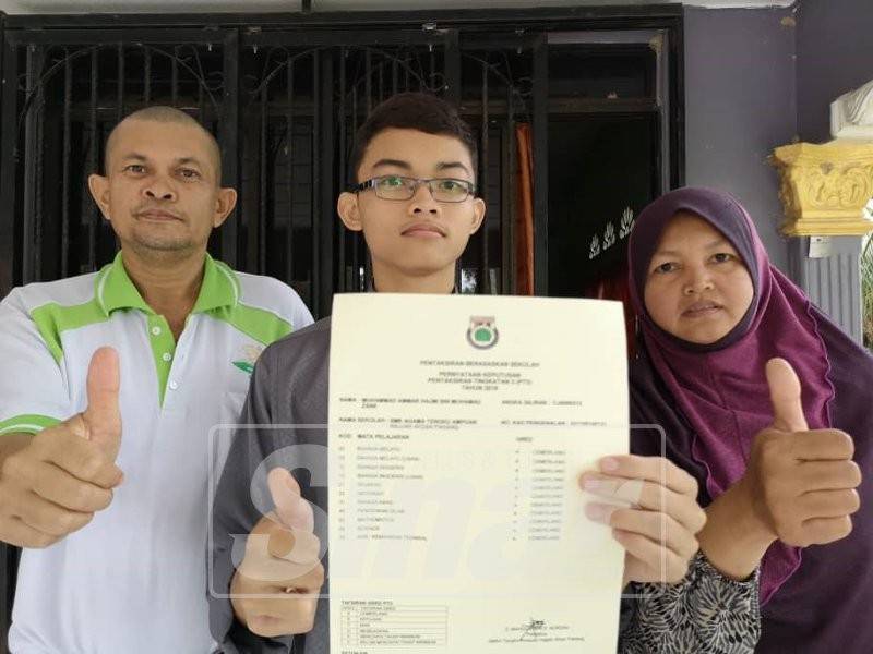 Muhammad Ammar yang memperoleh 11A di samping ibu bapanya, Zaini (kiri) dan Che Hasnah. 