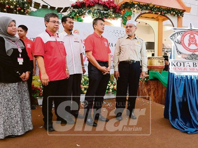 Ahmad (kanan) beramah mesra dengan Dr Zaini ketika merasmikan Hari Aids Sedunia di Aeon Mall, semalam.