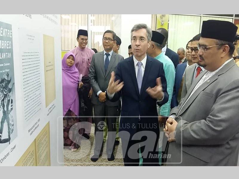 Mohamed Fadzli (kanan) mendengar penerangan daripada Laplanche di Pameran Seorang Etnologis Perancis Di Kelantan, di Perbadanan Perpustakaan Awam Kelantan, hari ini.