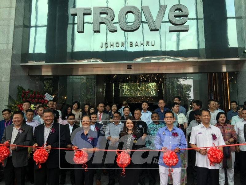 Cai Tung (tengah) bersama Mohamaddin ketika memotong riben gimik pembukaan Hotel Trove.