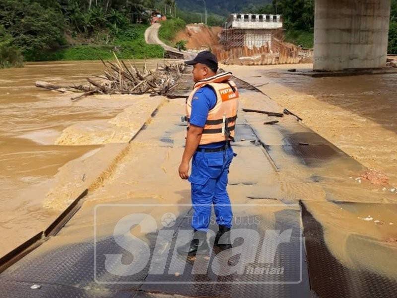 Anggota APM meninjau keadaan Sungai Neggiri di jambatan sementera Pulau Setelu.