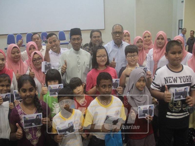 Ab Hamid diiringi Mohammad Fakhruddin merakamkan gambar bersama penerima bantuan pada program Majlis Bantuan Khas Persekolahan Menteri Besar Pahang di MTNP, di sini hari ini.
