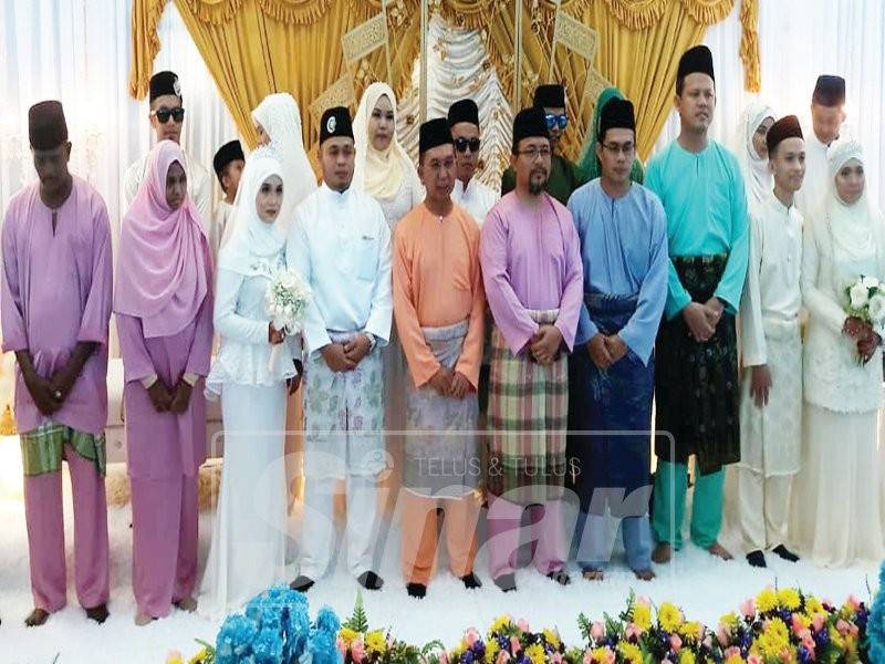 Bukhari (lima, kiri) bersama pasangan yang diijab kabul pada Program Nikah Beramai-Ramai ‘Sakinah Mawaddah Warahmah’ di Masjid Al Syifa’ Bandar Penawar, semalam.