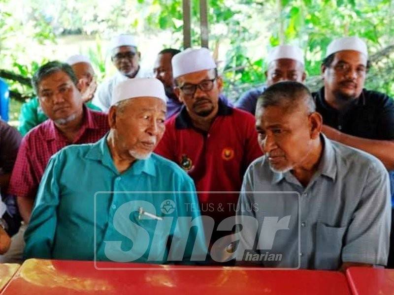 Hashim (kiri) bertanyakan sesuatu kepada bapa Allahyarham Muhammad Adib, Mohd Kassim Abd Hamid semasa menziarahi keluarga tersebut di Kampung Tebengau, Kuala Kedah. - Foto Facebook Pas