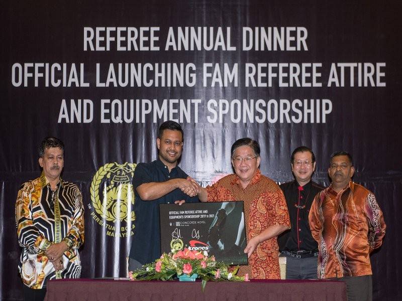 Stuart Ramalingam (dua, kiri) bersalaman dengan Pengarah Kronos Malaysia, Tiew Cheng Chai (tiga, kanan) sewaktu menandatangani dokumen penajaan ketika Majlis Makan Malam Pengadil dan Penilai Pengadil 2018 serta Pelancaran Pakaian dan Penajaan Peralatan Pengadil FAM bagi musim baharu malam semalam. - Foto Bernama