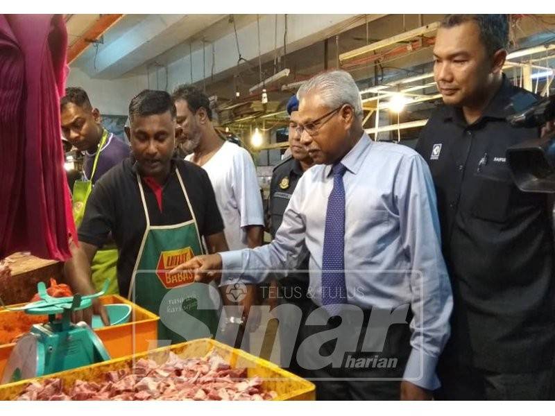 Sivanesan (dua, kanan) memeriksa harga kambing yang merupakan salah satu barang kawalan sepanjang musim perayaan sempena Hari Natal 2018 di Pasar Besar Ipoh.