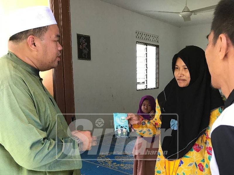 Shazuwan menyampaikan sumbangan kepada Norhayati dalam kunjungannya ke kediaman keluarga itu di Kampung Sat Tengah.