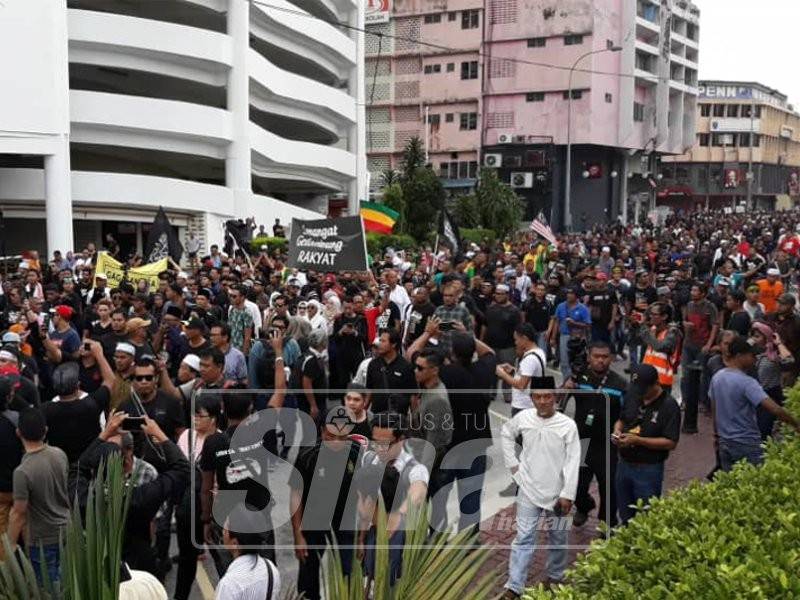 Peserta membawa sepanduk dan panji menuju ke Dataran Seni Klang.