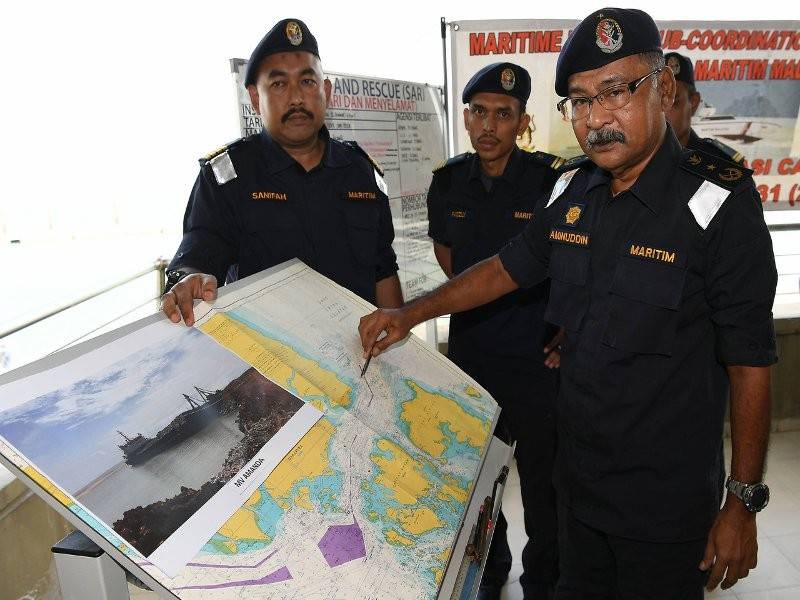 Pengarah Maritim Negeri Johor Laksamana Pertama Maritim Aminuddin Abdul Rashid menunjukkan kedudukan lokasi kapal dagang MV Amanda yang membawa sembilan kru, kesemuanya warga asing terbalik dan karam di perairan timur Tanjung Sepang, dekat sini, petang semalam pada sidang media Operasi Carilamat di Pos Maritim Tanjung Pengelih hari ini. Turut hadir Timbalan Pengarah Operasi Maritim Wilayah Selatan Kapten Maritim Sanifah Yusof (kiri).- Foto Bernama