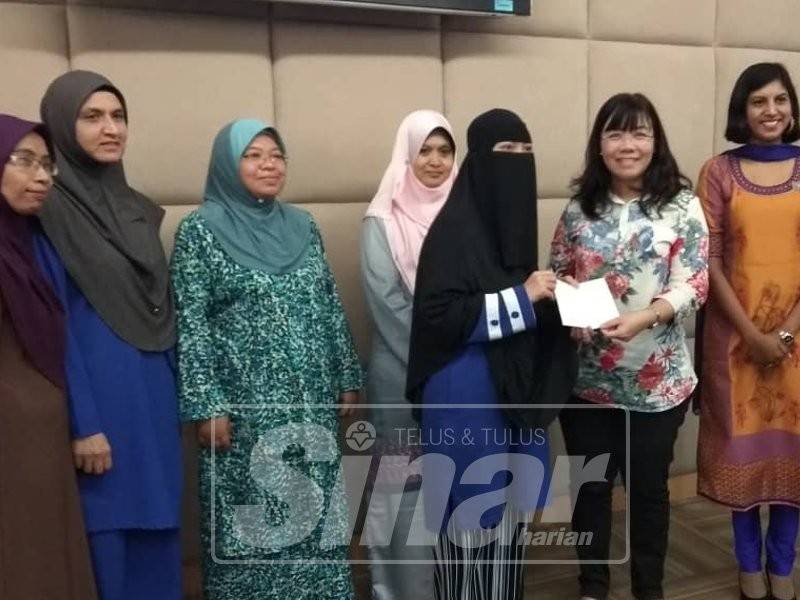 Noor Shalina (tiga, kanan) menerima cek sumbangan kerajaan negeri daripada May Ing pada majlis tersebut.