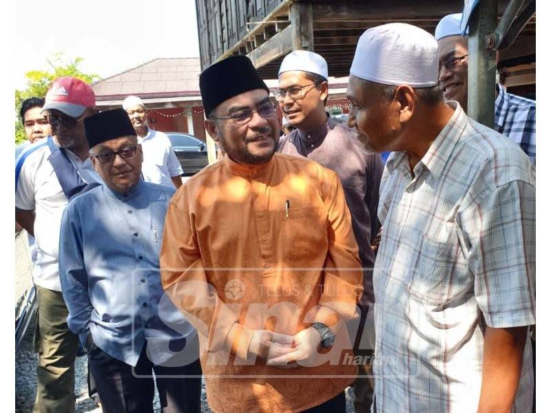 Dr Mujahid (dua, kanan) bersama Mohd Kassim ketika mengunjungi keluarga Allahyarham Muhammad Adib di Kampung Tebengau, dekat sini.
