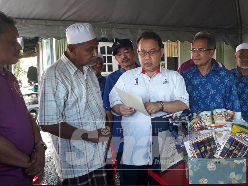 Abdul Fatah (empat, kanan) menunjukkan sijil koperasi milik Allahyarham Adib kepada Mohd Kassim.