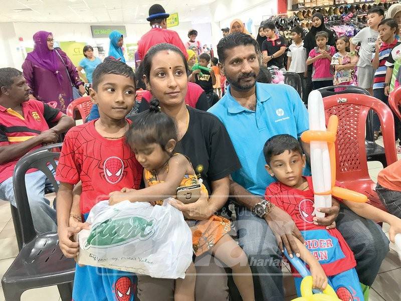 Sivakumar bersama isteri ketika berbelanja persekolahan dua anaknya hasil sumbangan HPSF di Pasaraya Besar Giant, baru-baru ini.