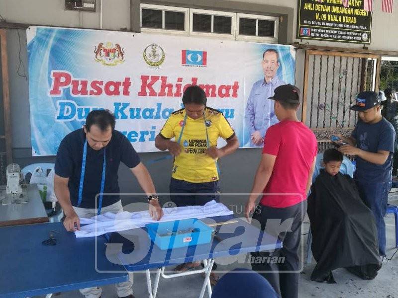 Abdul Yunus (kiri) tidak kekok membantu membaiki pakaian sekolah pelajar memerlukan sempena program Kembali Ke Sekolah 2019 di sini hari ini.