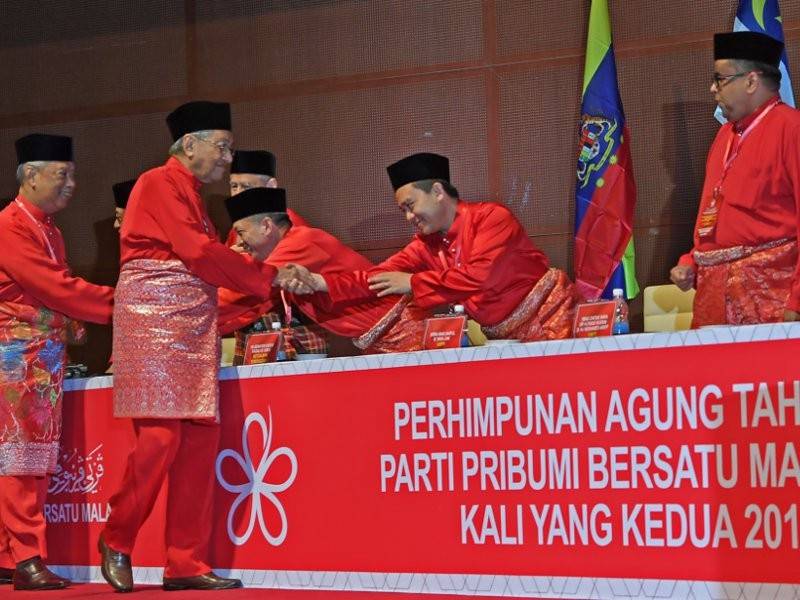 Pengerusi Parti Pribumi Bersatu Malaysia (Bersatu) Tun Dr Mahathir Mohamad (dua, kiri) dan Presiden Bersatu Tan Sri Muhyiddin Yassin (kiri) bersalaman dengan anggoya Majlis Pimpinan Tertinggi Bersatu semasa Perhimpunan Agung Tahunan Bersatu Kali Kedua 2018 di Pusat Konvensyen Antarabangsa Putrajaya (PICC) hari ini. - Foto Bernama