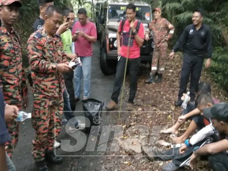 Anggota bomba meneliti keadaan tiga mangsa pelajar yang keletihan setelah tersesat di hutan Bukit Larut Taiping, hari ini.
