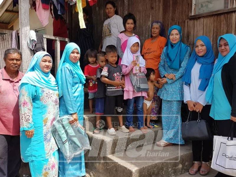 Ibu tunggal sembilan anak, Noraini Awang, 53, bersama anak-anaknya gembira menerima bantuan beg, peralatan sekolah dan wang tunai yang disampaikan Sharifah Norhayati.