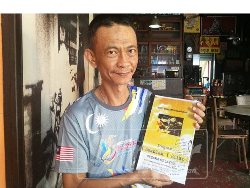 Abdul Wahid menunjukkan buku rujukan silat yang dihasilkan. 