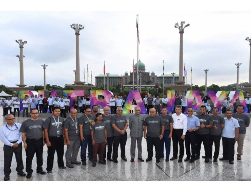 Mahathir bergambar bersama warga kerja Perbadanan Putrajaya dengan berlatarbelakangkan arca Putrajaya yang baru dirasmikan beliau di Dataran Putra hari ini. - Foto Bernama