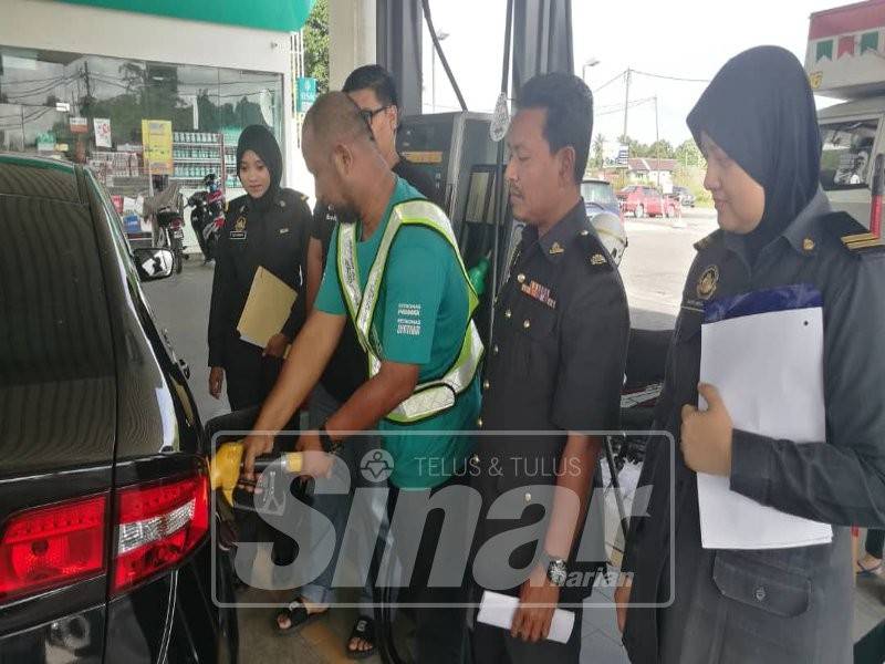 Wan Marzuki (dua kanan) melakukan pemantauan di sebuah stesen minyak di Tanah Merah.