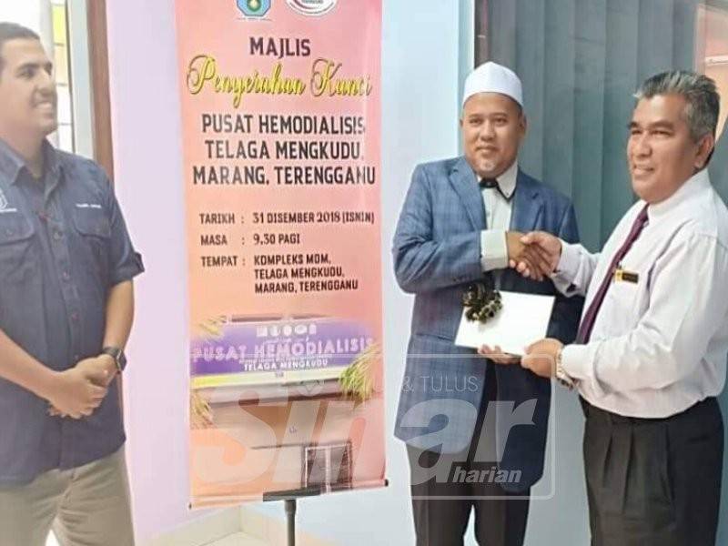 Ariffin menyerahkan kunci kepada Mohd (kanan) di Majlis Penyerahan Kunci Pusat Hemodialisis Telaga Mengkudu.
