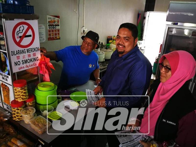 Dr Surinah (kanan), Taqiuddin (tengah) mengedarkan risalah larangan merokok di Arked Mara Pontian, hari ini.
