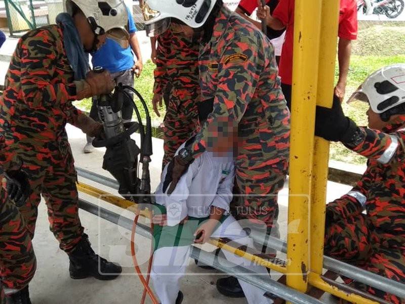 Anggota bomba menggunakan peralatan khas mengeluarkan kaki kiri mangsa yang tersepit di tempat duduk besi sebuah sekolah agama di Bandar Baru Salak Tinggi, tengah hari tadi.