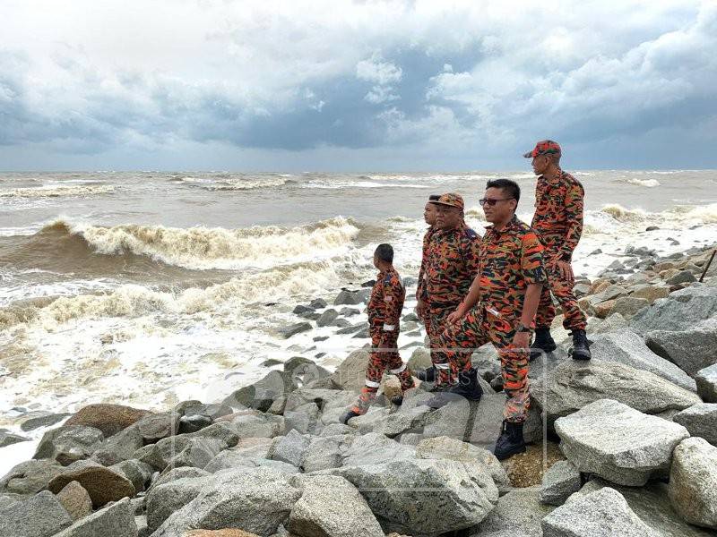 Nazili (kanan) semasa membuat tinjauan di kawasan pesisir Pantai Sabak, di sini.