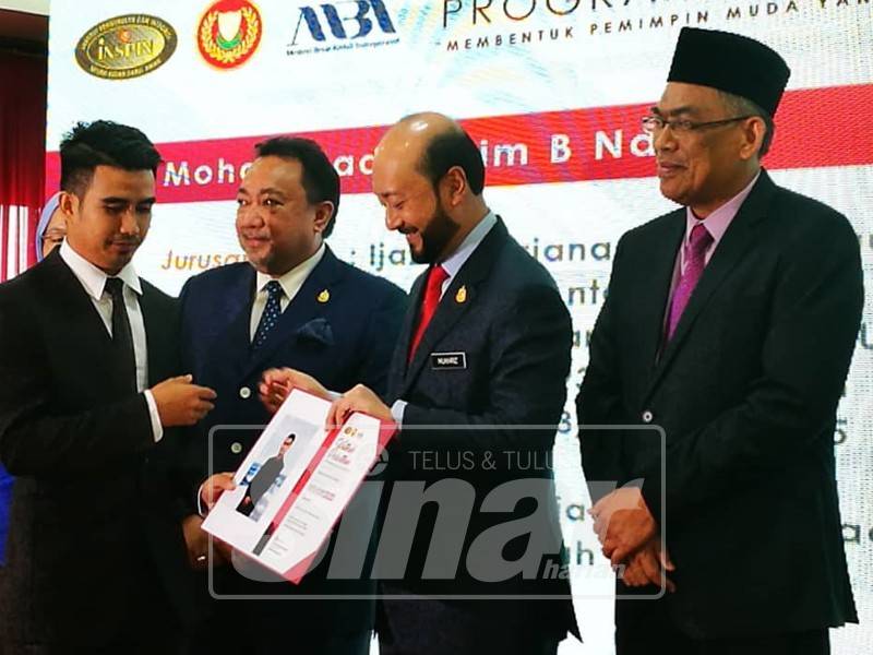 Mukhriz (dua, kanan) menyerahkan watikah pelantikan kepada pelatih program ‘Future Leaders’ di Wisma Darul Aman.