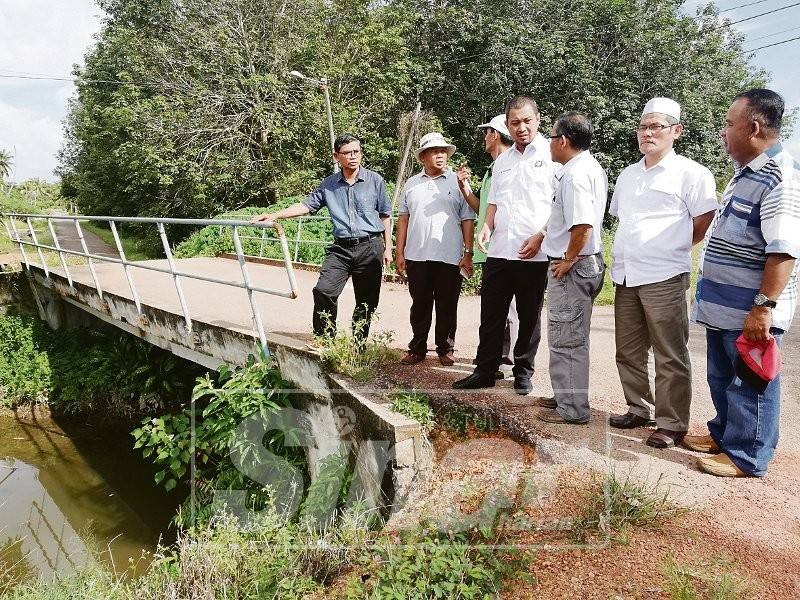 Dr Sahruddin (tengah) berbincang dengan pihak terlibat ketika mengadakan lawatan kerja di Kampung Panjang Sari.