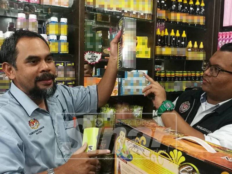 Mohd Wazir (kiri) menunjukkan antara produk meletakkan label tuntutan perubatan yang tidak dibenarkan.