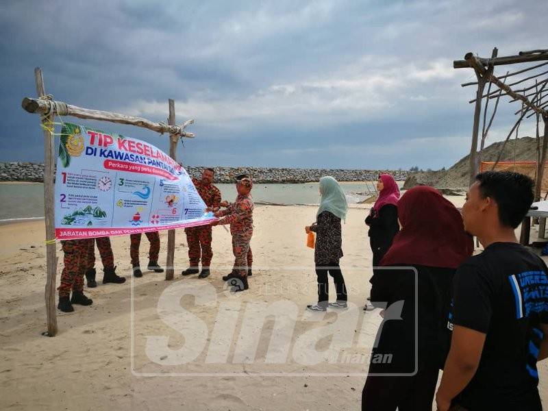 Sekumpulan anggota Balai Bomba dan Penyelamat Kuala Nerus memasang kain rentang di Pantai Tok Jembal.