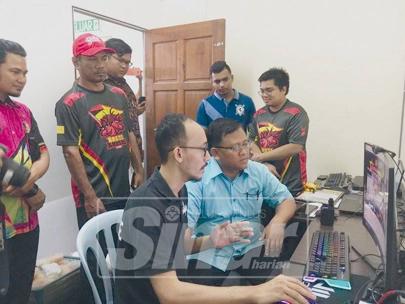 Mohamad Taufek (duduk, kanan) ditunjukkan perisian sukan e-Sport.