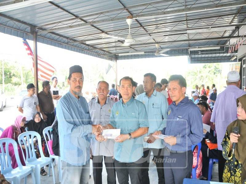 Abdul Yunus (tengah) menyerahkan sumbangan skim perlindungan takaful Tabarruk bernilai RM500 kepada 40 waris keluarga meninggal dunia di Dun Kuala Kurau dan Parlimen Bagan Serai dari 1 Ogos hingga 31 Disember 2018.