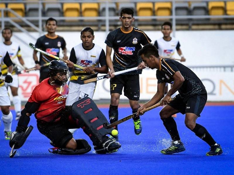 Pemain THT, Faizal Saari (kanan) mengasak para pemain Maybank pada perlawanan Separuh akhir TNB MHL Piala Tan Sri P. Alagendra 2019 di Stadium Hoki Nasional Bukit Jalil, hari ini. Kedudukan semasa THT 3 Maybank 1. - Foto Bernama