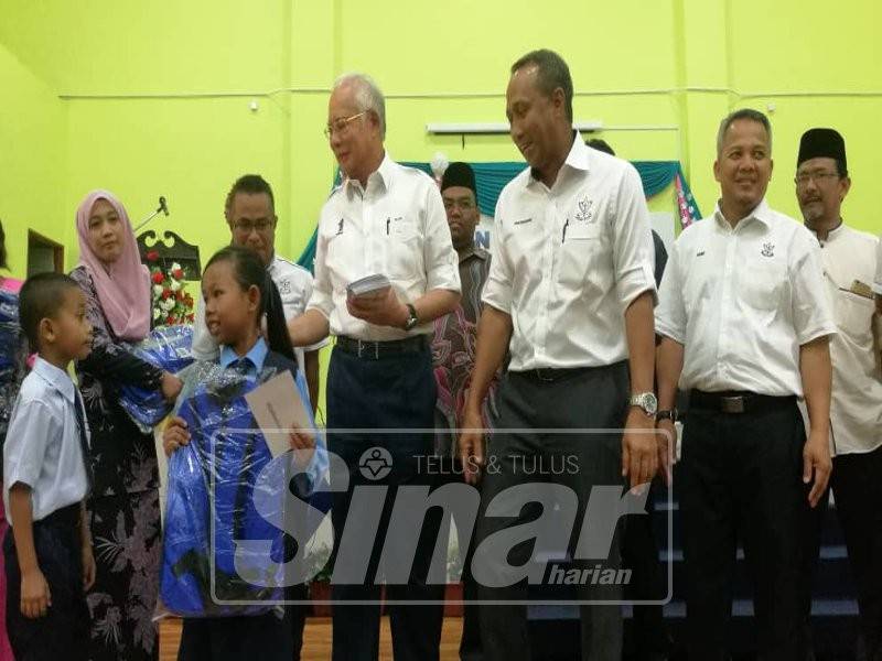 Najib (tiga, kanan) dan Fakhruddin menyampaikan sumbangan kepada 647 murid dari 14 buah sekolah dalam Dun Bebar.