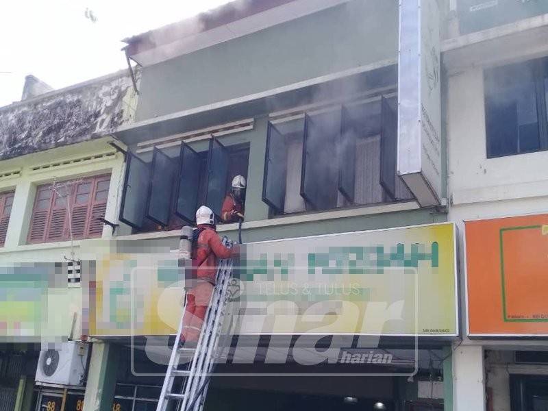 Anggota bomba dan penyelamat sedang memadam kebakaran yang berlaku di rumah kedai tersebut.