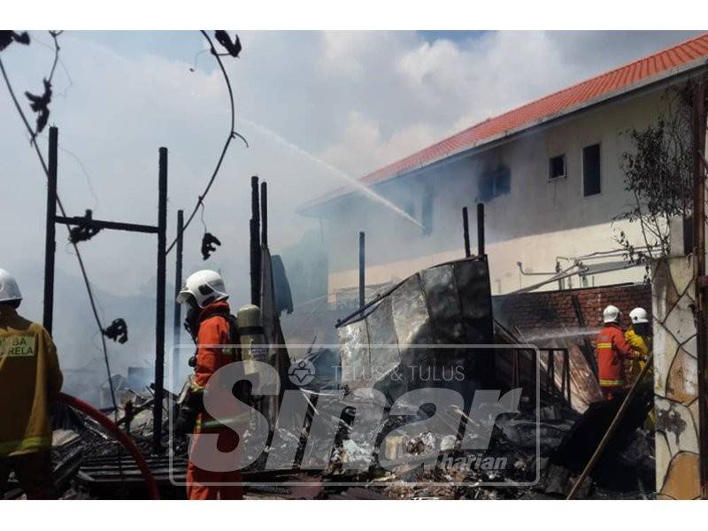 Bomba bertungkus lumus mengawal kebakaran dari merebak.