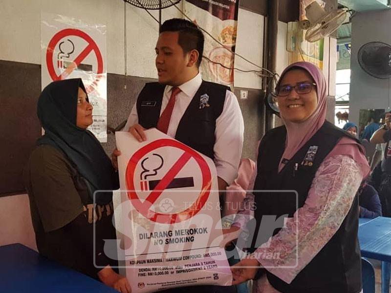 Afif memberi tanda larangan merokok kepada salah seorang pemilik kedai.