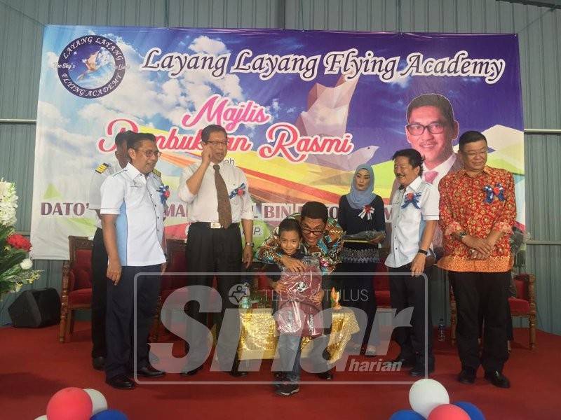 Ahmad Faizal (tengah) bergambar dengan salah seorang pelajar yang menerima sumbangan beg sekolah pada majlis berkenaan.