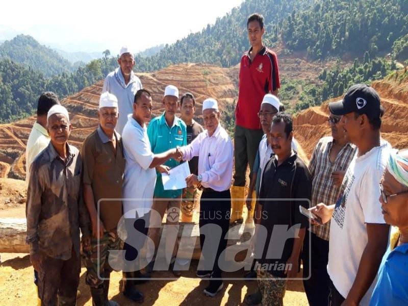 Malik pengerusi Bertindak serah salinan memorandum kepada Abd Nasir kanan di tapak projek.